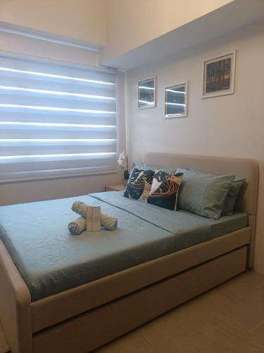 a bedroom with a bed with a teddy bear on it at Carol sweet room in Cebu City