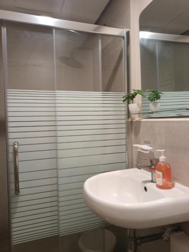a bathroom with a sink and a glass shower at Carol sweet room in Cebu City
