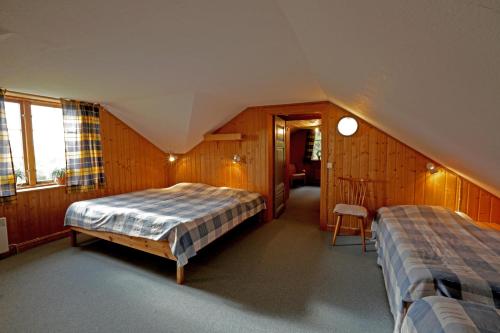 Schlafzimmer im Dachgeschoss mit 2 Betten und einem Stuhl in der Unterkunft Haus Klockar in Brograngen
