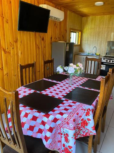 a dining room table with a red and white checkered table cloth at Cabañas Anny 2 in Linares
