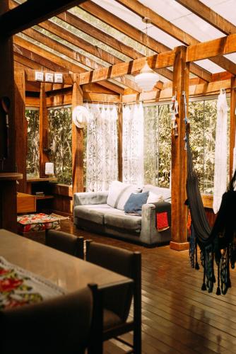 a living room with a couch and a hammock at Casa de Madeira - Sao Jorge GO in Sao Jorge