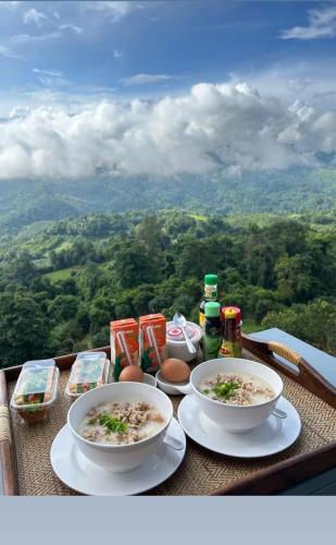 a table with two bowls of food on it with a view at เดอะเบสภูลังกาพะเยา in Ban Sakoen
