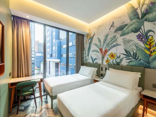 a hotel room with two beds and a mural at Hotel Waterloo Singapore - Handwritten Collection in Singapore