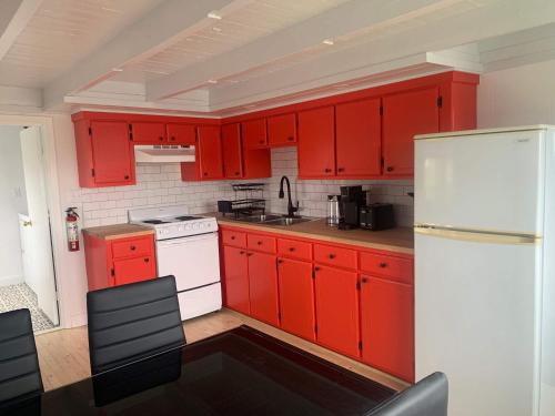 a kitchen with red cabinets and a white refrigerator at Iceberg Lookout in Twillingate