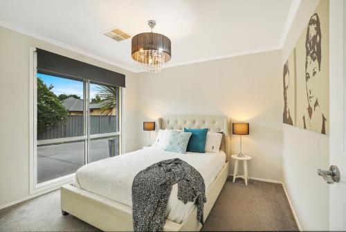 a bedroom with a bed and a large window at Belle in Bowral in Bowral