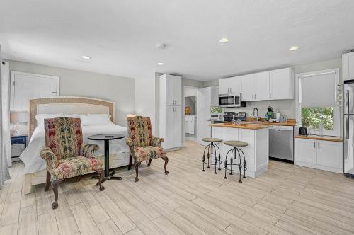 a bedroom with a bed and two chairs and a kitchen at The Reserve Retreat in Sarasota