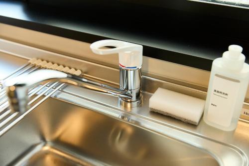 a sink with a faucet and a roll of paper towels at One room in a newly built condominium in Tokyo