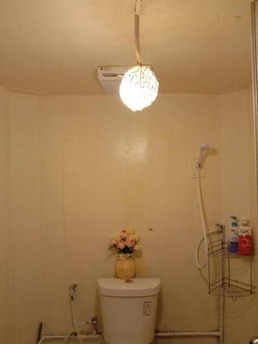 a bathroom with a toilet with a flower vase on it at Homestay with Rive View Bann Good View in Ban Hua Phrong