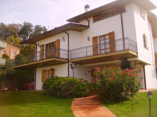 a white house with a balcony and some flowers at B&B Margherita Le Fiabe in SantʼAgata Feltria