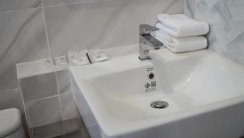 a white bathroom sink with towels on top of it at Tiny house bangtao phuket in Ban Thalat Choeng Thale
