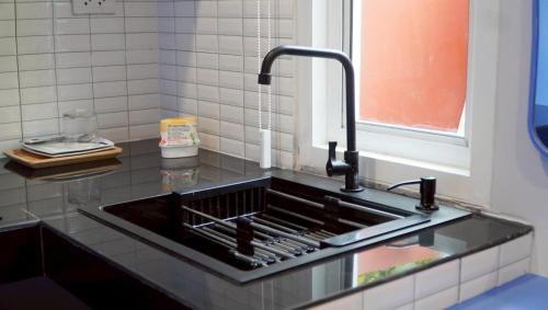 a kitchen counter with a sink and a window at Tiny house bangtao phuket in Ban Thalat Choeng Thale