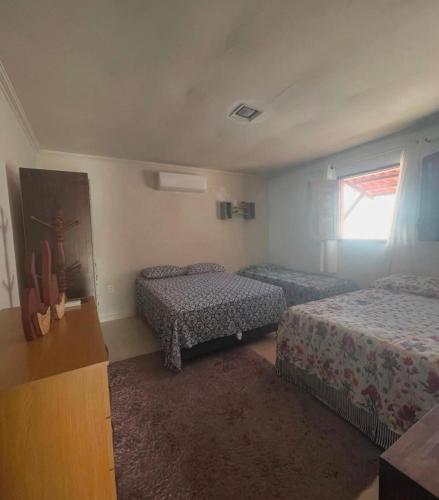 a hotel room with two beds and a window at Casa temporada frances in Marechal Deodoro