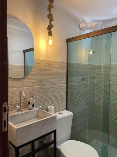 a bathroom with a sink and a toilet and a mirror at Casa temporada frances in Marechal Deodoro