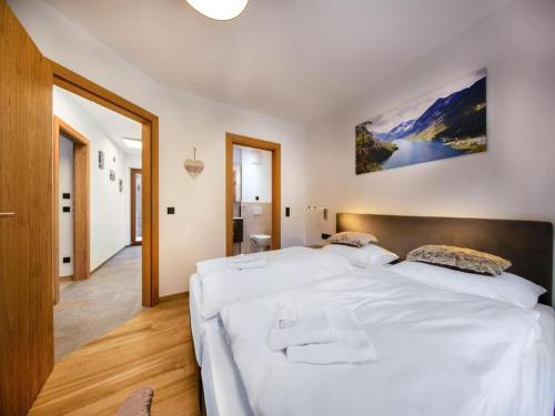 a bedroom with a large bed with white sheets at Luxury alpine chalet in Neukirchen in Neukirchen am Großvenediger