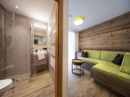 a bathroom with a green couch and a shower at Chalet in Neukirchen for 8 people in Neukirchen am Großvenediger
