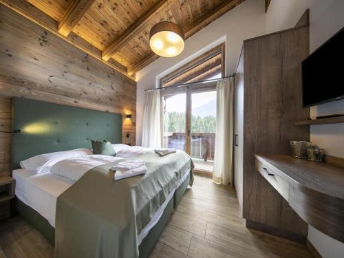 a bedroom with a large bed and a large window at Chalet in Neukirchen for 8 people in Neukirchen am Großvenediger