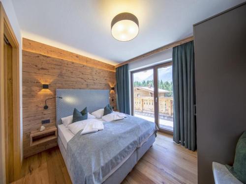 a bedroom with a bed and a large window at Chalet with sauna, Neukirchen in Neukirchen am Großvenediger