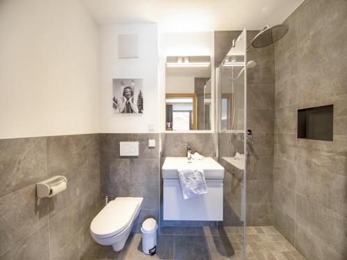 a bathroom with a sink and a toilet and a mirror at Chalet with sauna, Neukirchen in Neukirchen am Großvenediger