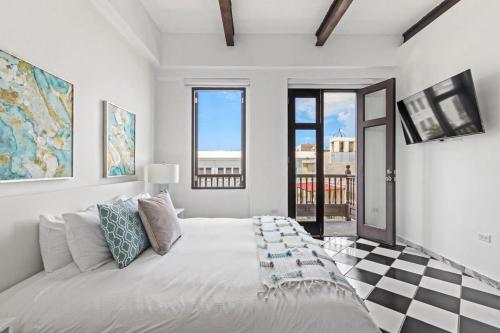 a white bedroom with a bed with a checkerboard floor at Mint Suite - 1 BR in Old San Juan in San Juan