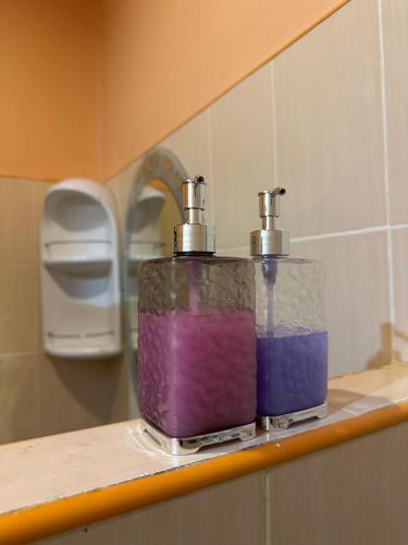 two containers of colored liquid sitting on a shelf in a bathroom at Phu Lanta Life Resort in Ko Lanta
