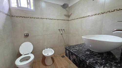 a bathroom with a sink and a toilet and a tub at Complejo de cabañas Vida Paz in Las Calles
