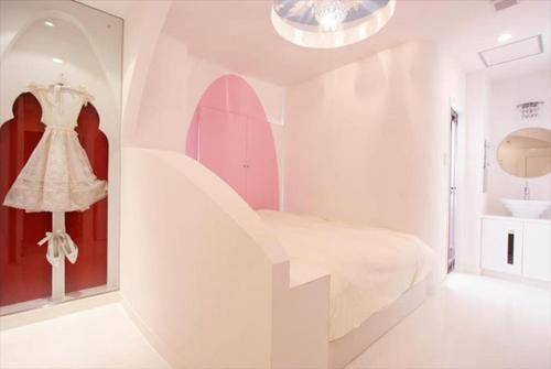 a white room with a white bed and a staircase at HOTEL DCUBE in Tokyo