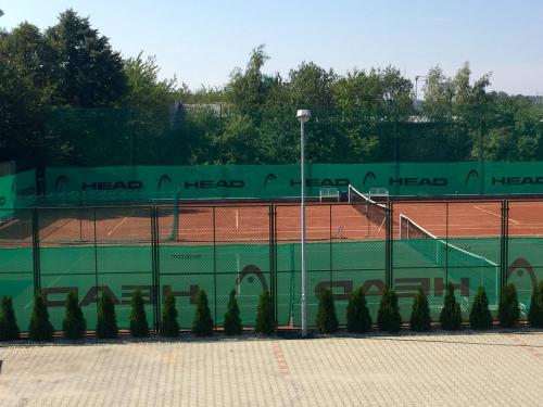 a tennis court with a fence on a tennis court at Motel R10 in Mladá Boleslav