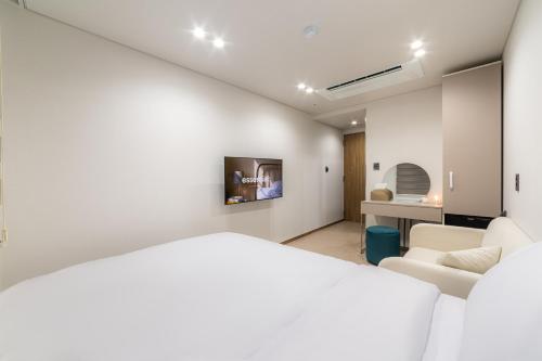 a white room with a bed and a couch at lazy tiger hotel in Seoul