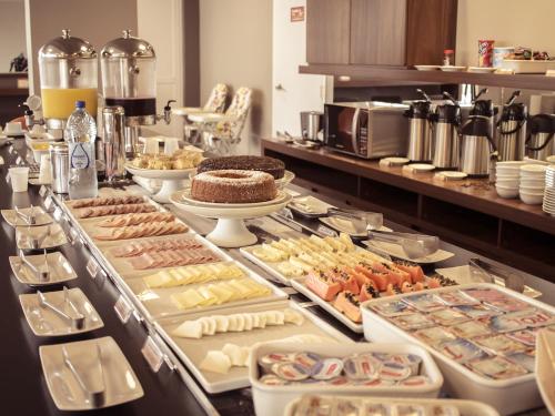 a kitchen filled with lots of different types of pastries at Hotel 10 Ponta Grossa in Ponta Grossa