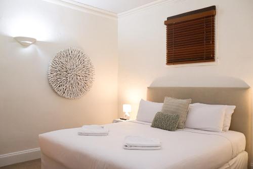 a bedroom with a white bed with towels on it at Kaesler Cottages in Nuriootpa