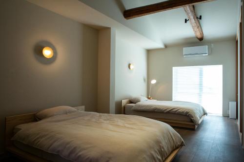 a bedroom with two beds and a window at SOUQ Renovated Townhouse in Himeji Quiet Market District in Himeji