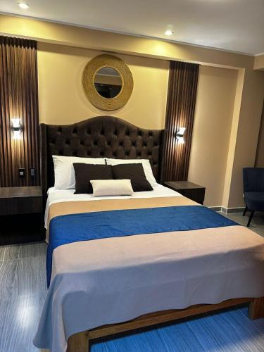 a bedroom with a large bed with a blue blanket at Gran Hotel in Yungay