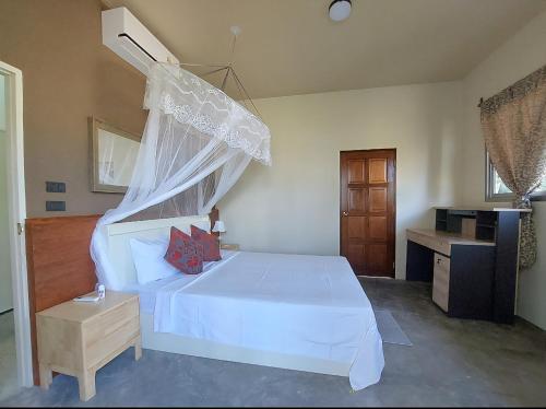 a bedroom with a white bed and a desk at Tha Khao Beach House 1 in Ban Bang Chak