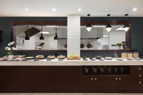 a kitchen with many plates of food on a counter at Swiss-Belhotel Napier in Napier