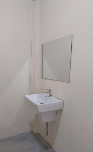 a bathroom with a white sink and a mirror at Tha Khao Beach House 1 in Ban Bang Chak