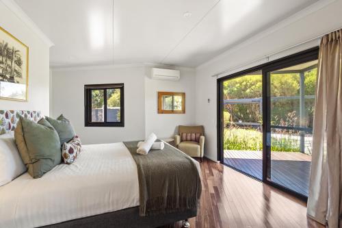 a bedroom with a bed and a sliding glass door at Hartzell One Seven - Private - Family Friendly in Wilyabrup