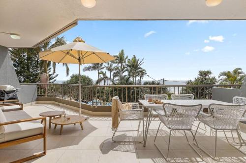 a patio with a table and chairs and an umbrella at The Rocks Resort Unit 2C in Gold Coast
