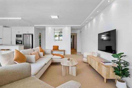 a living room with a white couch and a table at The Rocks Resort Unit 2C in Gold Coast