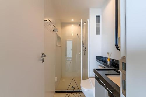 a white bathroom with a shower and a toilet at RN Studio Premium – Your Seaside Retreat in Maceió