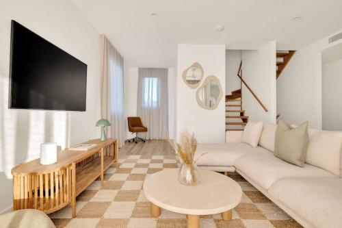 a living room with a couch and a tv at Salt Tugun in Gold Coast