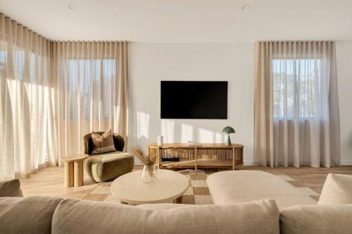 a living room with a couch and a tv at Salt Tugun in Gold Coast