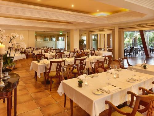 a restaurant with tables and chairs with white tablecloths at Ria Park Hotel & Spa in Vale do Lobo