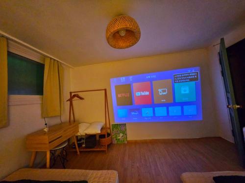 a living room with a large screen on the wall at 윤 작가의 숙소 in Seoul