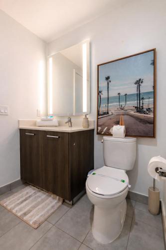 a bathroom with a toilet and a sink and a mirror at Downtown Skyline Heights with Stunning Ocean View in Miami