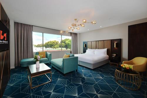 a hotel room with a bed and chairs at Swiss-Belhotel Napier in Napier