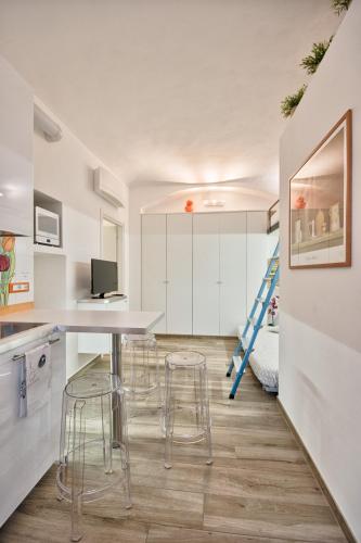 a kitchen and dining room with a table and stools at LittleAndCosy in Turin