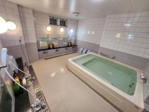 a bathroom with a large tub in the middle at ホテル青木 in Ina