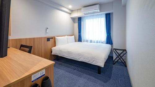 a small room with a bed and a window at Toyoko Inn Sendai Higashi-guchi No.1 in Sendai