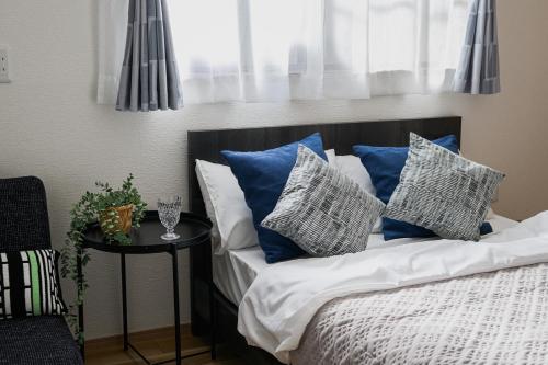 a bed with blue and white pillows and a window at Direct Haneda Access &Onsen 1-min Walk SAMURAI STAY ZEN in Tokyo