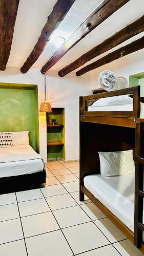 a bedroom with two bunk beds and a tiled floor at THIS IS COLOMBIA HOSTEL in San Gil